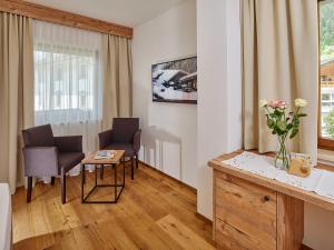 施图拜河谷新施蒂夫特尚恩霍夫酒店的客厅配有两把椅子和一张鲜花桌