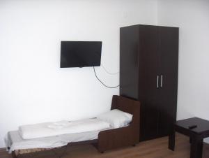 贝尔科维察克拉斯特瓦酒店的一间卧室配有橱柜和墙上的电视