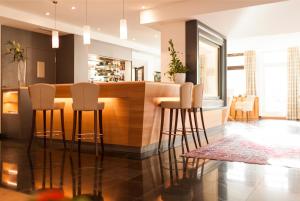 圣坎迪朵斯特范尼亚别墅酒店的厨房设有带白色凳子的酒吧
