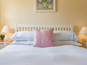 PettShepherds Cottage的一张白色的床,上面有粉红色的枕头