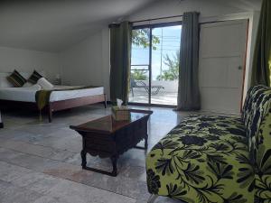 班帕那普兰The Beach Boutique Resort的一间卧室配有一张床、一张沙发和一张桌子