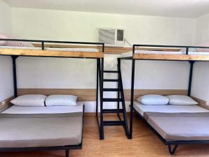 GindiViento de Mar的带梯子的客房内的三张双层床