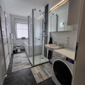 大雷申Ferienwohnung NR1的带淋浴、盥洗盆和洗衣机的浴室