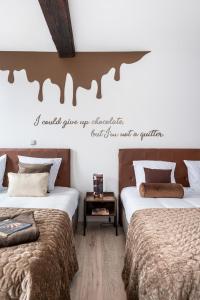 布鲁日The Chocolate Suites的卧室配有两张床,墙上有一段名言