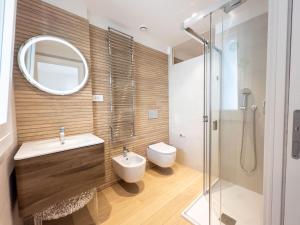 卡利亚里Bina Luxury Apartment的一间带水槽、卫生间和镜子的浴室