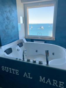 塔兰托Suite al mare的带浴缸的浴室和窗户