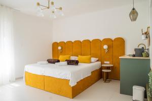 斯普利特Style rooms Split的一间卧室配有一张带黄色枕头的大型木制床。