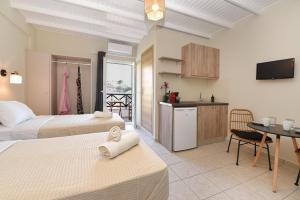 梅加斯·亚洛斯-奈特斯Glafki Studios Syros的一间带两张床的卧室和一间带桌子的厨房