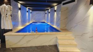 耶路撒冷Lago Suites Hotel的一座大型游泳池,位于一间铺有石板的房间内