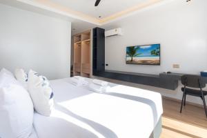 芭东海滩By The Beach Home in Patong的卧室配有白色的床和书桌