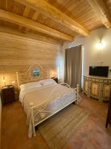 迪亚诺达尔巴Cascina Maina的卧室配有一张床铺,位于带木墙的房间内