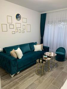帕拉钦Apartman Diamond的客厅配有绿色沙发和桌子
