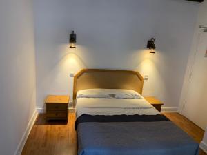 巴黎达芬奇II酒店的卧室配有一张带两盏灯的墙壁床。