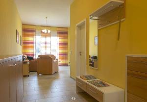 奥茨塞巴德·迪尔哈根SONNENSEGEL App Nr 04 max 3 Pers的客厅设有黄色的墙壁和沙发
