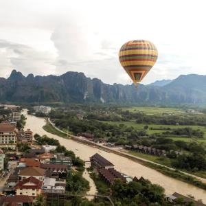万荣万荣岩石背包客旅舍的空中的热气球飞越河流
