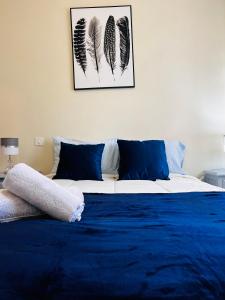 凡道Nogueira Country House的一间卧室配有一张带蓝色床单和羽毛的床。