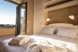 埃皮斯科皮·罗希姆诺Villa Manoutsio的一间卧室设有一张大床和大窗户