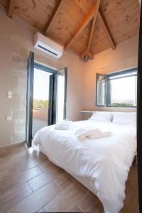 埃皮斯科皮·罗希姆诺Villa Manoutsio的卧室设有一张白色大床和一扇窗户。