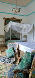 杰拉切Palazzo Caracciolo的一间卧室配有一张带天蓬的大床