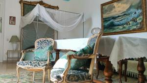杰拉切Palazzo Caracciolo的客厅配有两把椅子和一张桌子