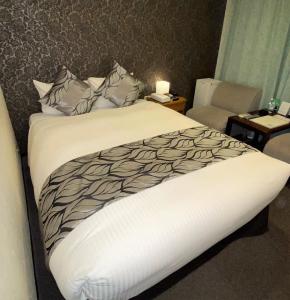 东京Roppongi Plaza Hotel的卧室配有带白色棉被的床