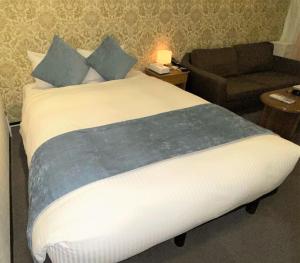 东京Roppongi Plaza Hotel的一间卧室配有一张带椅子和沙发的床