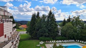 圣恩吉玛Ferienwohnung Maggie - Sankt Englmar的设有一个游泳池的度假村阳台,享有风景