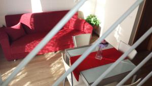 阿尔塔穆拉Panorama Lucano的客厅配有红色的沙发和桌子