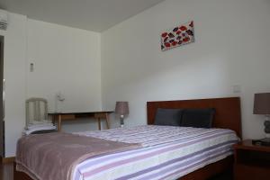 莱里亚Casa da Fonte Quente的一间卧室配有一张床和一张桌子及钢琴