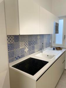 奥特朗托Elementi Luxury House的厨房配有水槽和白色橱柜