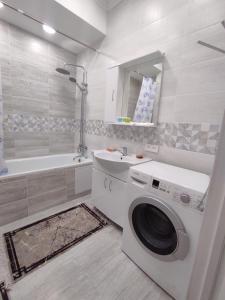 阿拉木图Уютная квартира-студия ЖК Lotus Terrace的一间带洗衣机和水槽的浴室