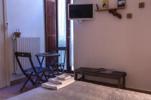 特拉尼4 Camere A Trani的一间带床和两把椅子的房间以及一台电视
