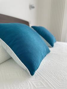 奥特朗托Elementi Luxury House的床上的2个蓝色枕头