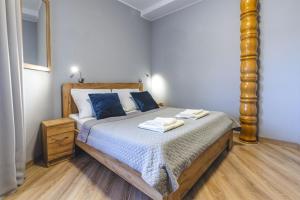 格但斯克Royal Gdansk的一间卧室配有一张带蓝色枕头的大床