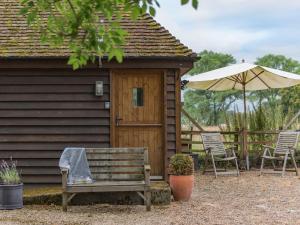 HollingbourneHeron Barn的小木屋配有长凳和遮阳伞