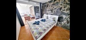 卡门港villa del mar puerto del carmen的一间卧室设有一张床和石墙