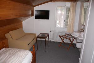 维尔德斯韦尔巴伊兰贝尔酒店的一间卧室配有一张床、一把椅子和电视