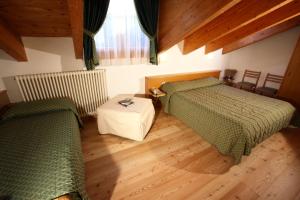 圣洛伦佐因巴纳莱内米比亚加尼酒店的一间卧室设有两张绿色的床,铺有木地板