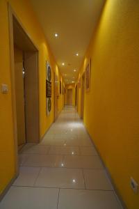 海德堡海德堡公寓酒店的一条空的走廊,有黄色的墙壁和瓷砖地板