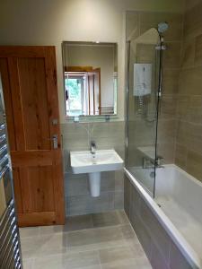 皮特洛赫里Braeside Cottage - Adorable 2 Bedroom Eco-Friendly Character Cottage的浴室配有水槽、淋浴和浴缸。