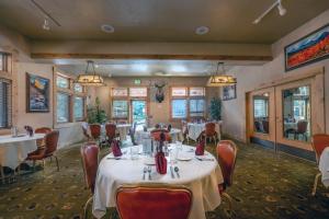 阿尔派恩飞行鞍度假酒店及牛排馆的用餐室设有桌椅和窗户。
