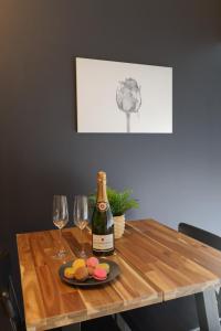 AulnatSpa & Love - Balnéo - Queen size - Cocooning的一张桌子,上面放着一瓶葡萄酒和两杯酒
