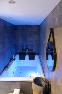AulnatSpa & Love - Balnéo - Queen size - Cocooning的蓝色的浴室设有浴缸和镜子