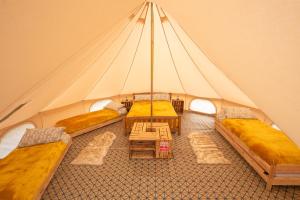Upper HulmeRoaches Retreat Eco Glampsite - Hen Cloud View Bell Tent的帐篷配有三张床和一张桌子
