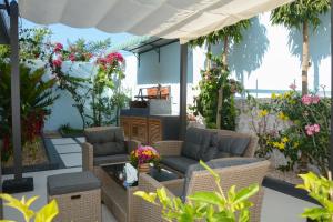 吉汶瓦Bless Villa Apartment的一座带藤椅和鲜花的庭院