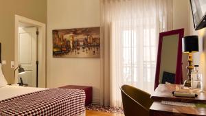 里斯本莎杜卡萨杜拜鲁旅馆的一间卧室配有一张床、一张书桌和一个窗户。