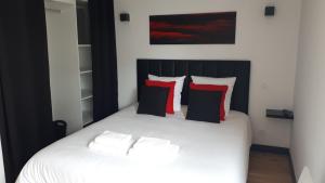 圣米歇尔-谢夫谢夫Maison et grande terrasse face mer的卧室配有白色的床和红色和黑色枕头