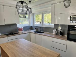 萨拉热窝Villa EMIR的厨房配有白色橱柜和木制台面