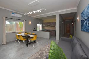 吉汶瓦Bless Villa Apartment的客厅以及带桌椅的厨房。