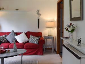 克里夫Tree Tops的客厅配有红色的沙发和桌子